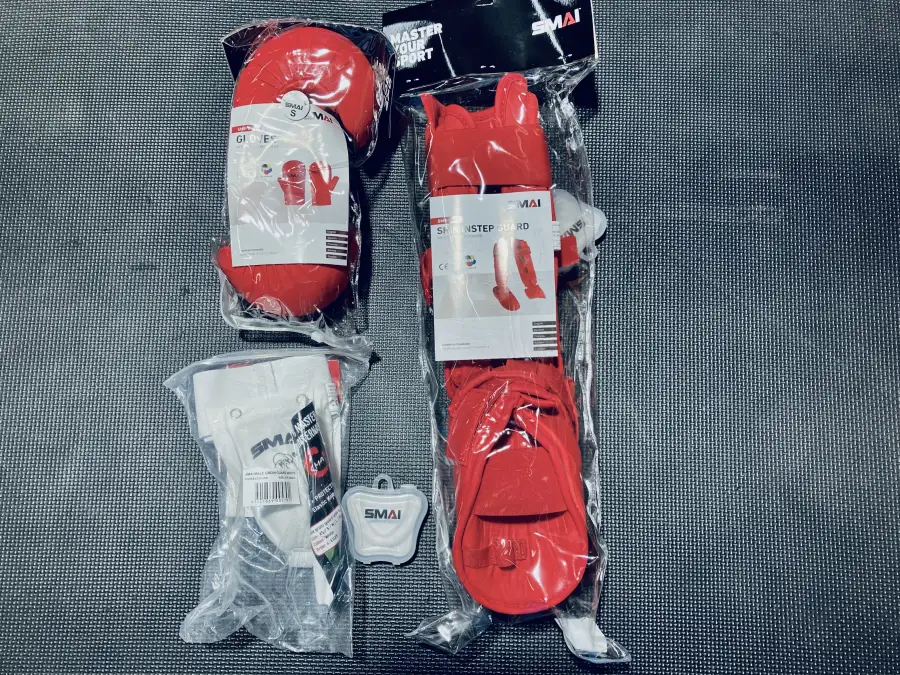 SMAI sparring gear laid out before a kumite session — gloves, shin guards, groin guard and mouthguard